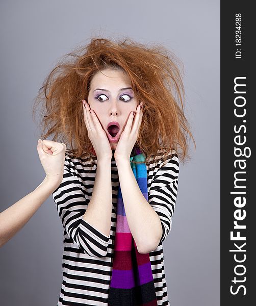 Surprised girl and hand with fist. Studio shot.