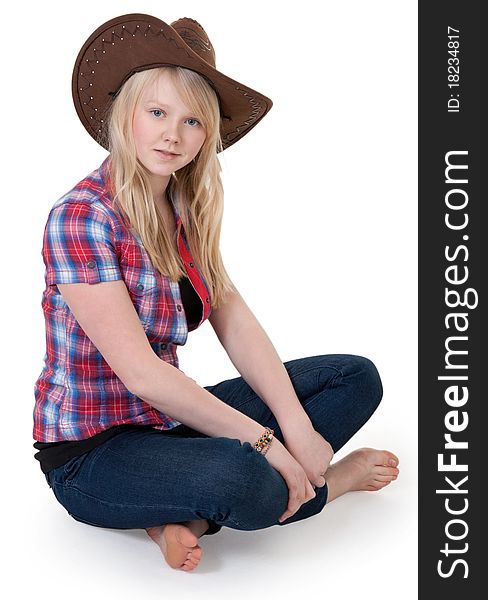 Beautiful girl in a cowboy hat sitting in the lotus position