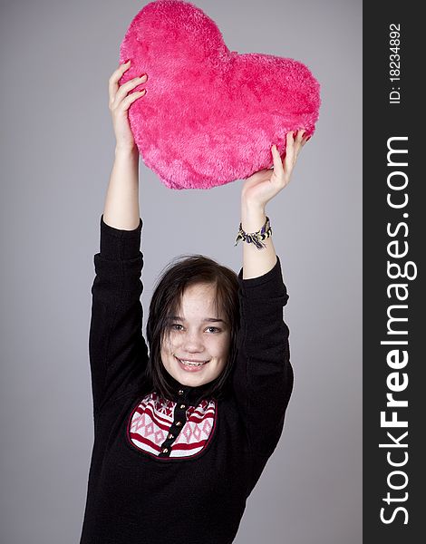 Funny gril with toy heart. Studio shot. Funny gril with toy heart. Studio shot.