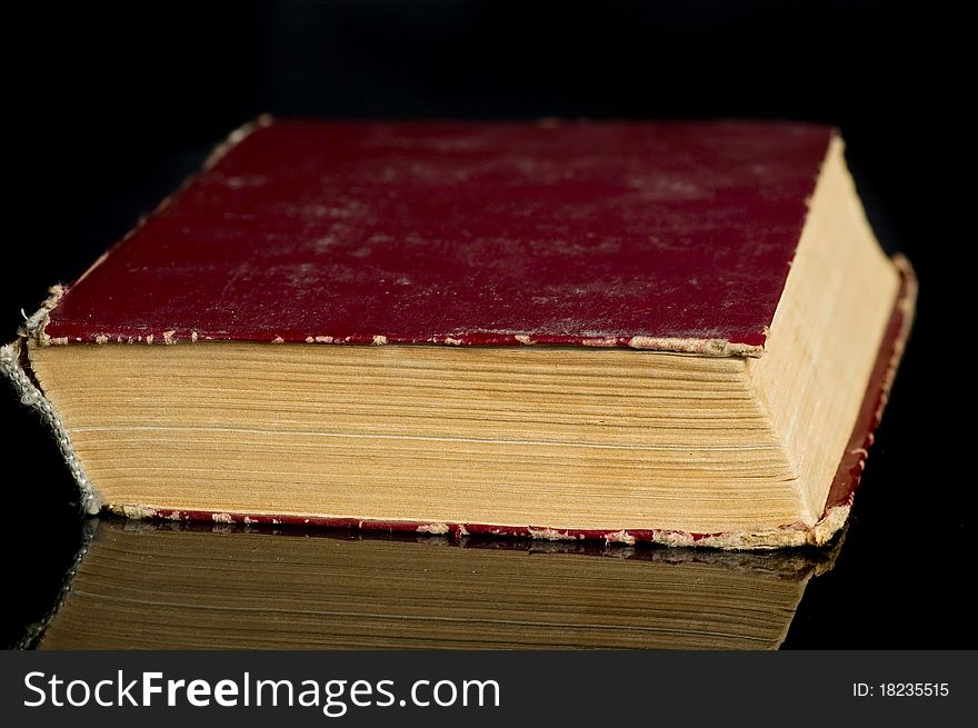 Old book with reflection on black