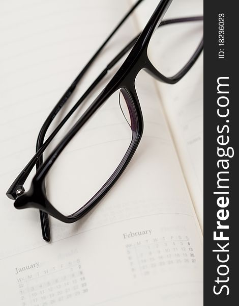 Glasses in black frames and paper notebook