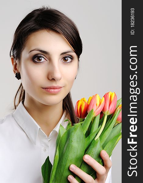 A young woman holding a bunch of orange tulips. A young woman holding a bunch of orange tulips