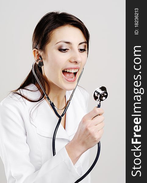An image of young doctor shouts in a stethoscope. An image of young doctor shouts in a stethoscope