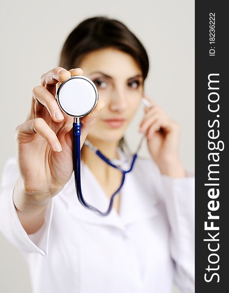 An image of young female doctor holding stethoscope to camera. An image of young female doctor holding stethoscope to camera