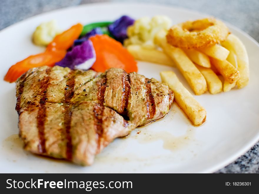 Grilled pork steak set with french fries and vegetable