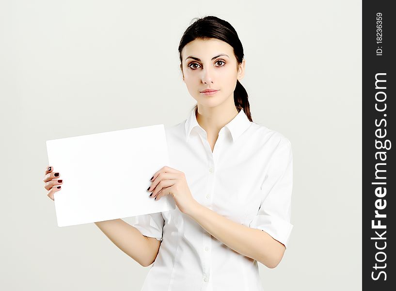 An image of young woman holding white paper. An image of young woman holding white paper