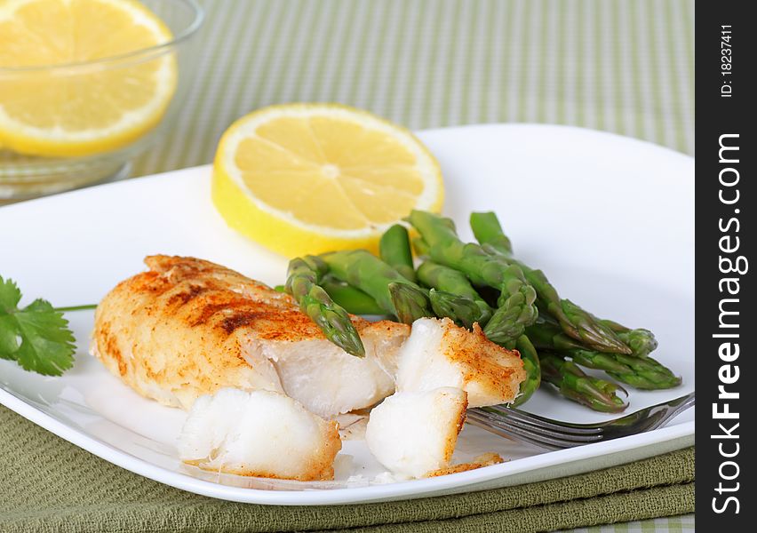 Fish fillet with asparagus and sliced lemon. Fish fillet with asparagus and sliced lemon