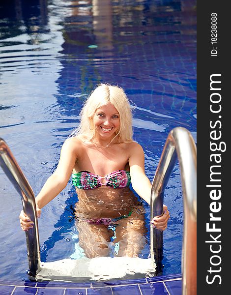 Attractive Woman On The Swimming Pool Ladder
