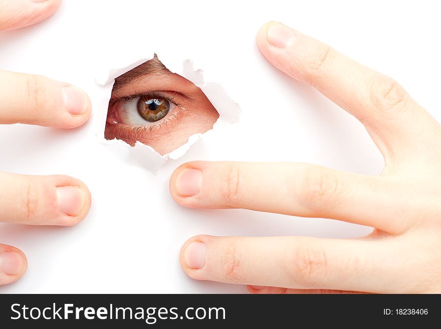 A man looks out a large hole in the white wall. A man looks out a large hole in the white wall