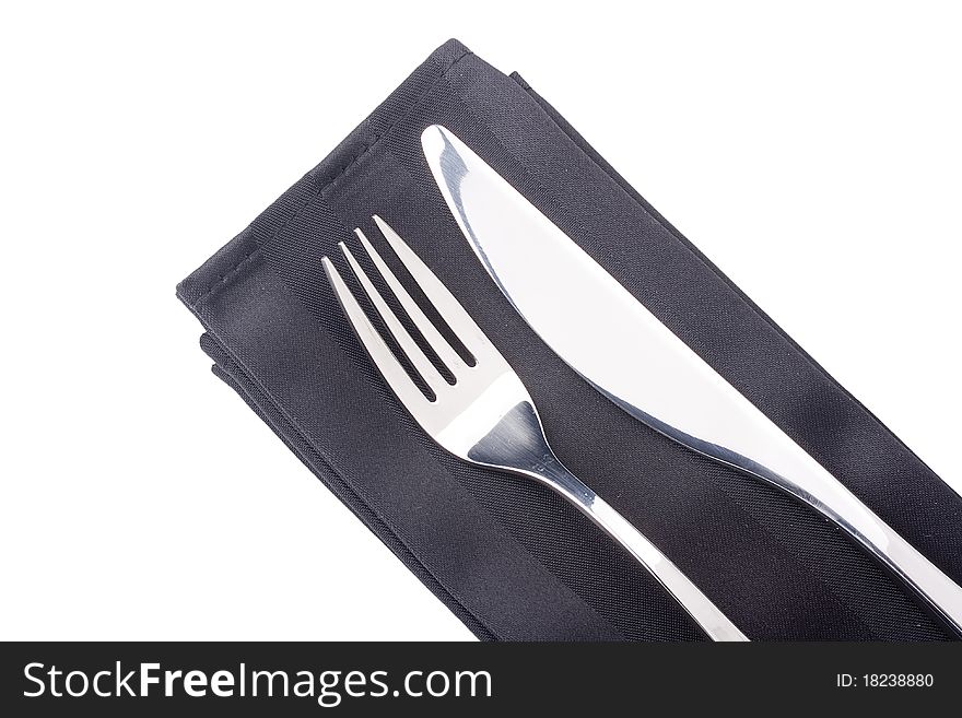 Knife and fork on a black napkin - tableware.