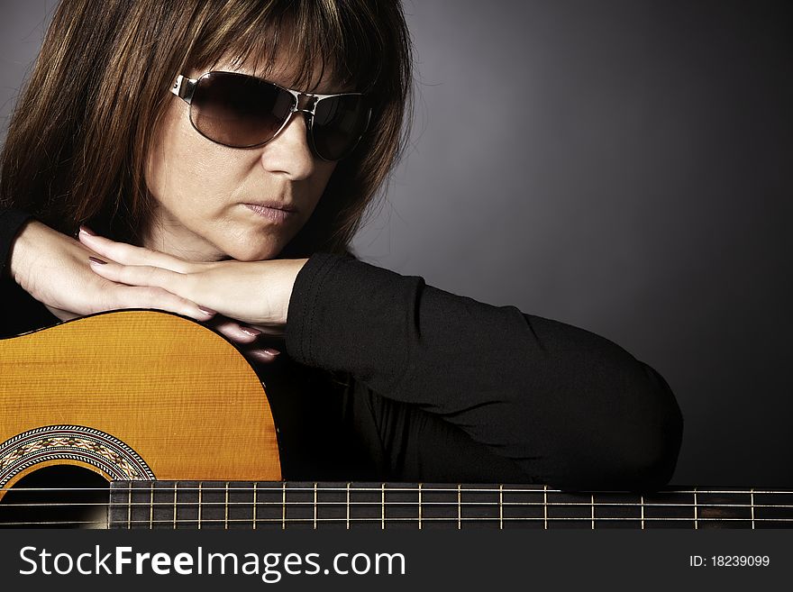 Woman leaning on guitar.