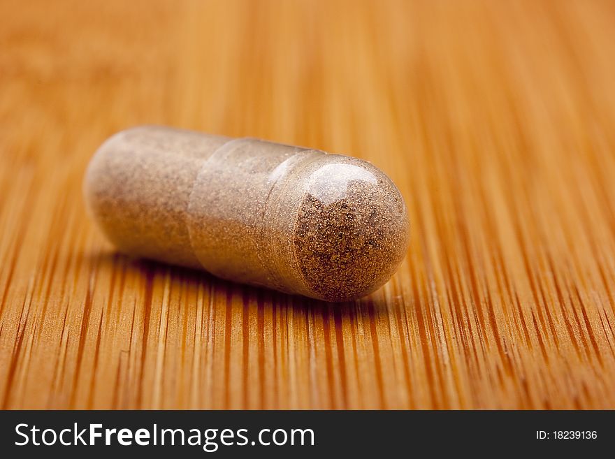 Medical pill against diseases on a wooden table.