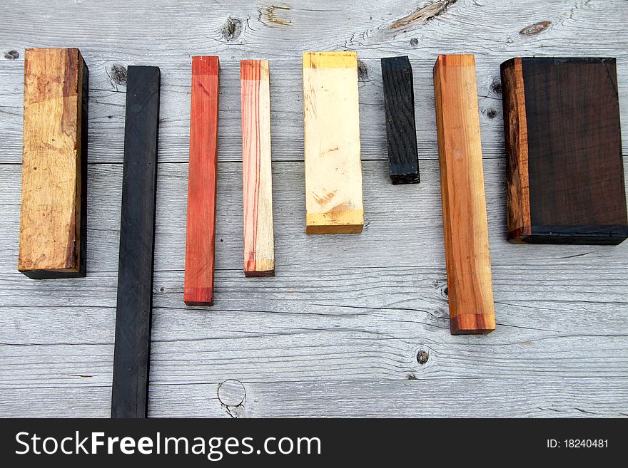 Various pieces of wood in a row - from above - on old wood panel