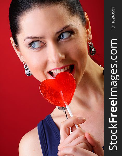 Beautiful young woman holding a red heart. Valentine concept