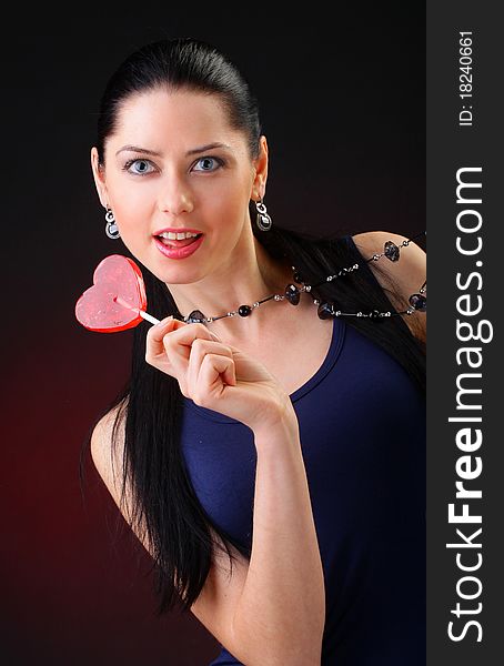 Beautiful young woman holding a red heart. Valentine concept
