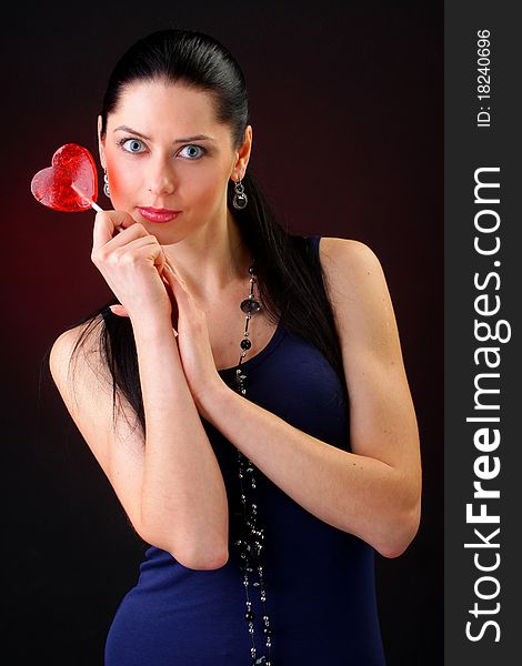 Beautiful young woman holding a red heart. Valentine concept