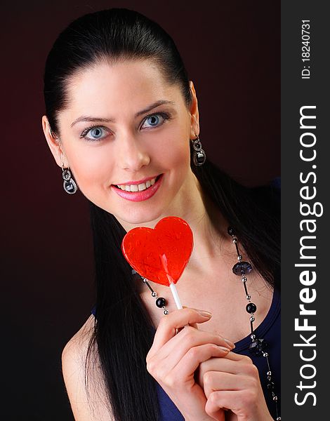 Beautiful young woman holding a red heart. Valentine concept