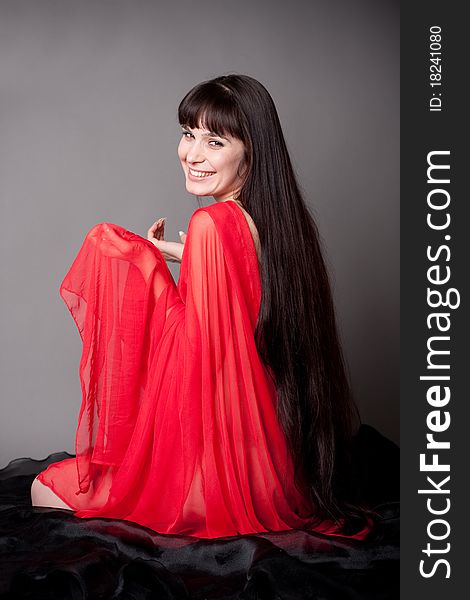 The beautiful long-haired girl sits on a floor and prepares for meditation. The beautiful long-haired girl sits on a floor and prepares for meditation