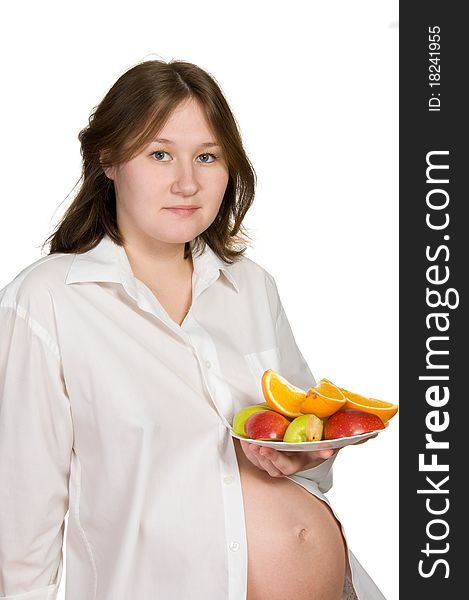 Adorable pregnant woman with fruits over white. Adorable pregnant woman with fruits over white