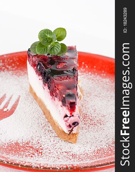 Fruit cheesecake with mint and fork imprint.