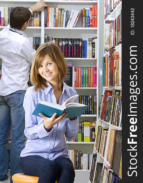 Young beautiful woman reading in the library