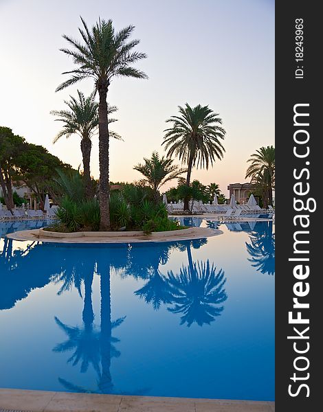 Sunrise on resort swimming pool with lounge chairs. Sunrise on resort swimming pool with lounge chairs