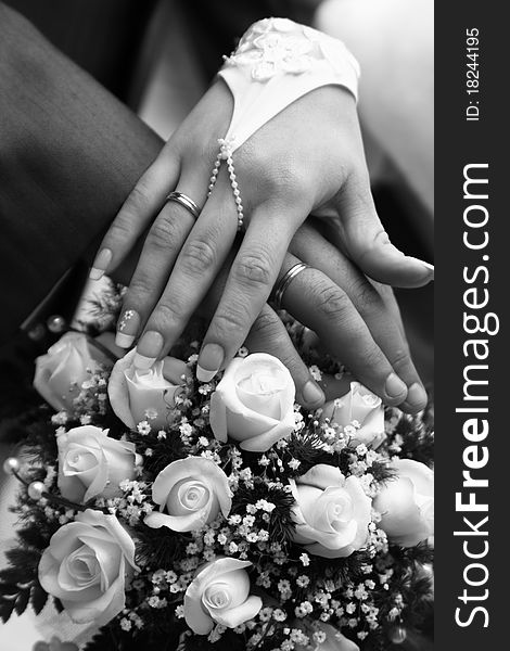 Hands on a background the Wedding bouquet whiht roses