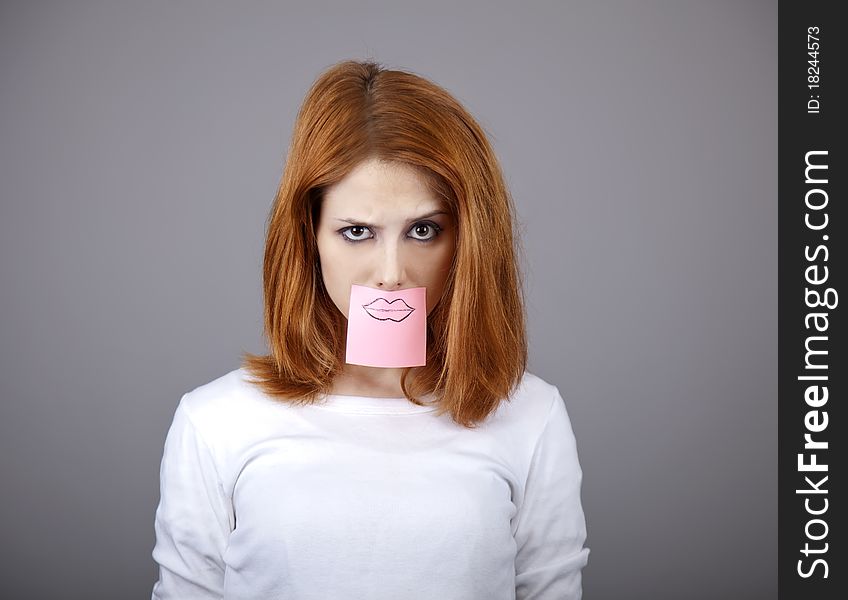 Portrait of red-haired girl with colorful funny stickers on mouth. Studio shot. Portrait of red-haired girl with colorful funny stickers on mouth. Studio shot.