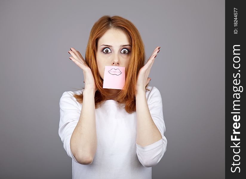 Portrait of red-haired girl with colorful funny stickers on mouth. Studio shot. Portrait of red-haired girl with colorful funny stickers on mouth. Studio shot.