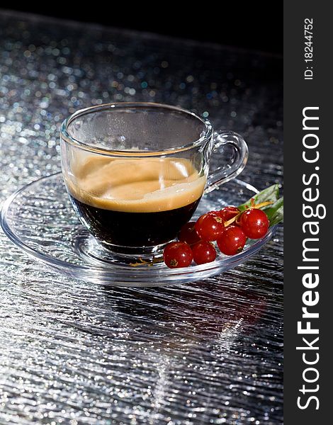 Photo of espresso coffee with currants on black glasstable. Photo of espresso coffee with currants on black glasstable