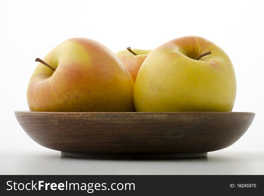 Three apples in a wooden bowl