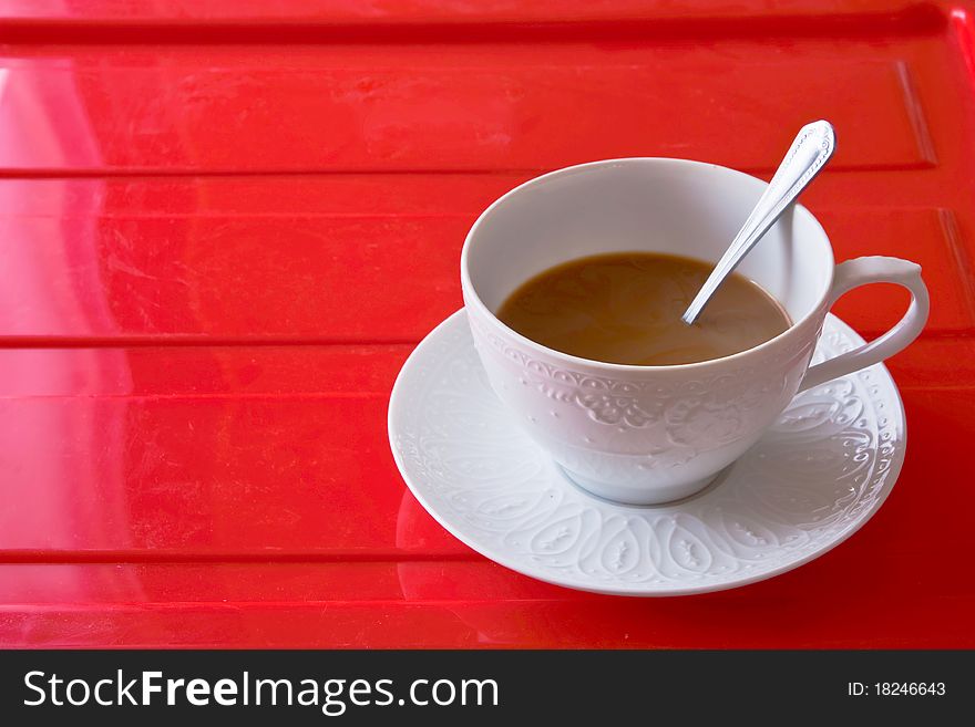 A white  cup of coffee on red background