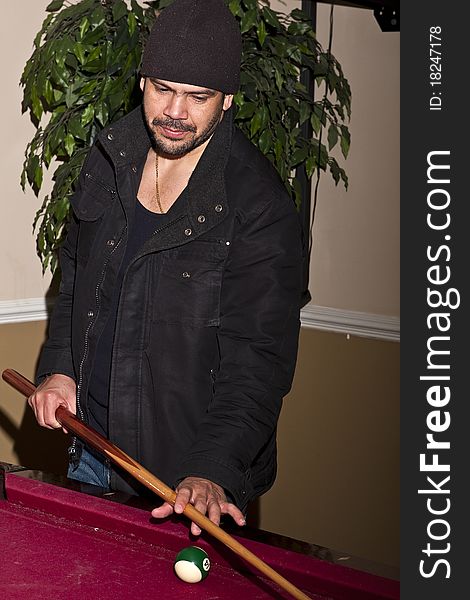 Latino guy playing pool table