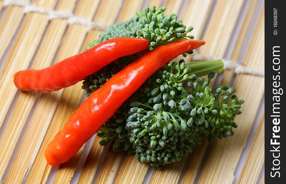 Pepper and broccoli over wooden background.