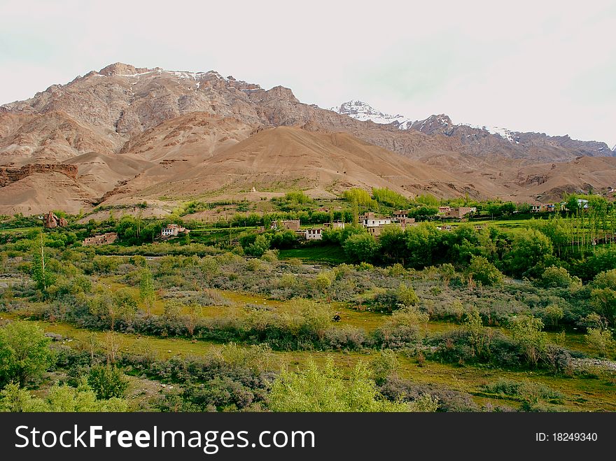 A beautiful Himalayan landscape with vast mountain range and greenery with isolated houses. A beautiful Himalayan landscape with vast mountain range and greenery with isolated houses.
