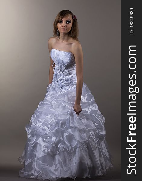 Beautiful brunette bride in the studio on a gray background