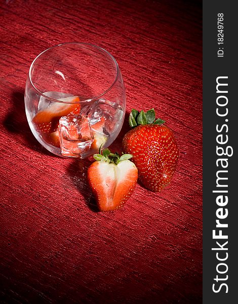 Photo of strawberries on ice on red table. Photo of strawberries on ice on red table