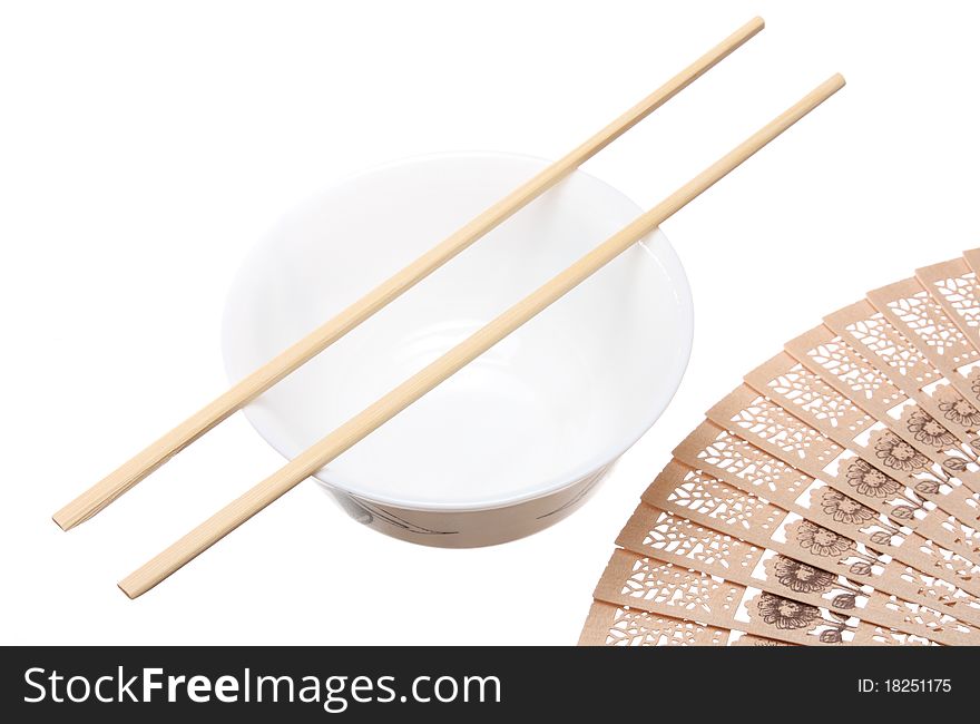 Chopsticks on the bowl and wooden fan isolated on white