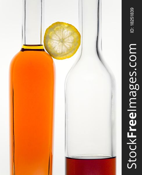 Two bottles and lemons part on white background