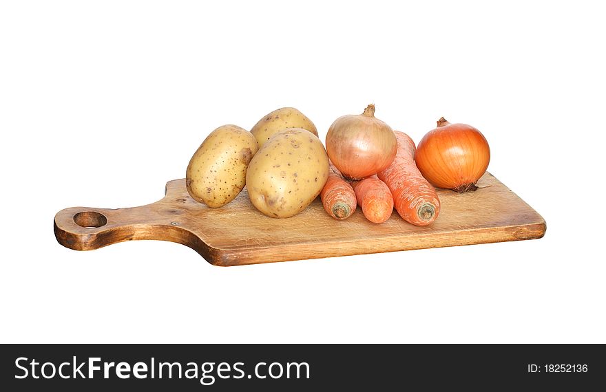 Few raw vegetables lying on wooden hardboard. Isolated on white with clipping path