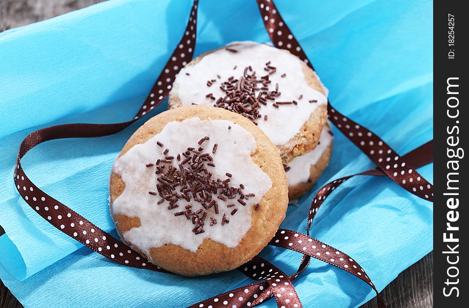 Cookies decorated with brown polka dots ribbon on the blue paper. Cookies decorated with brown polka dots ribbon on the blue paper