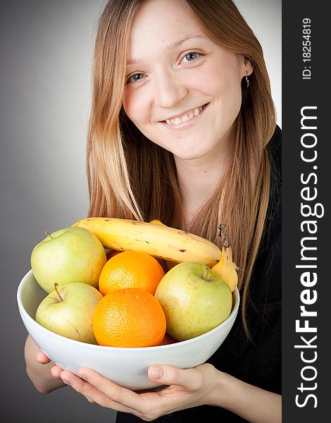 Pretty Blond Holding Healthy Fruit with Grey Background