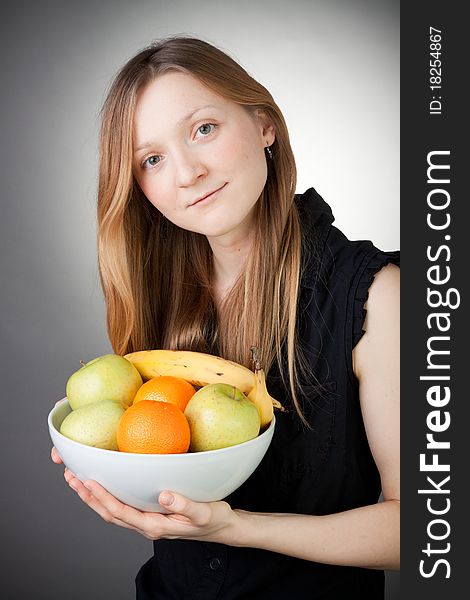 Pretty Blond Holding Healthy Fruit with Grey Background