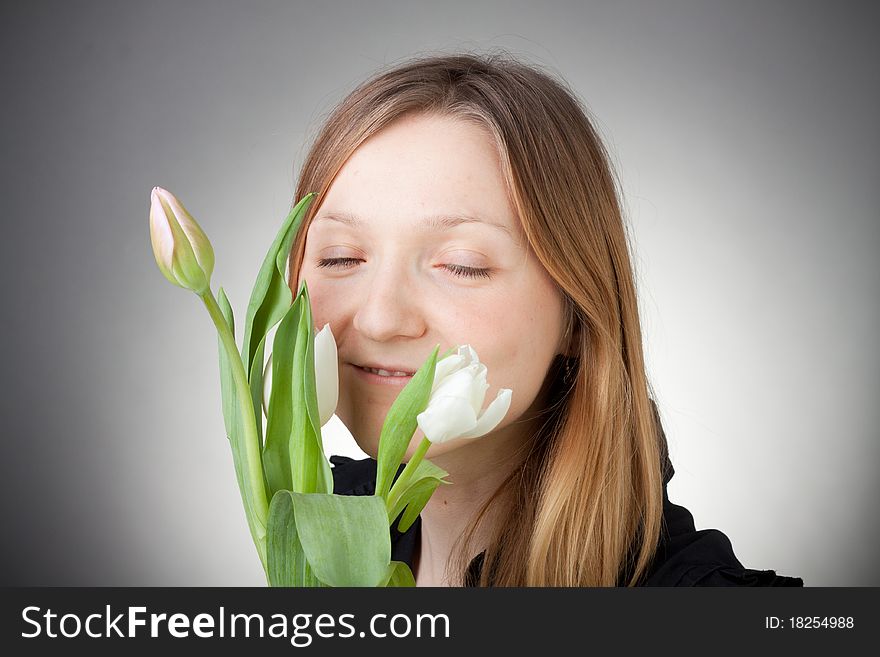 Young girl with tulips, with grey background. Young girl with tulips, with grey background