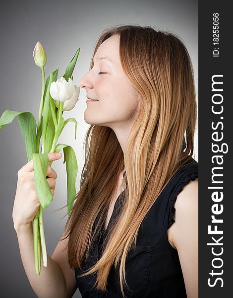 Young girl with tulips, with grey background. Young girl with tulips, with grey background