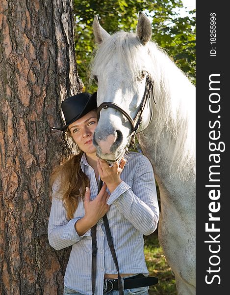 Portrait of young woman with her white horse in the woods. Portrait of young woman with her white horse in the woods