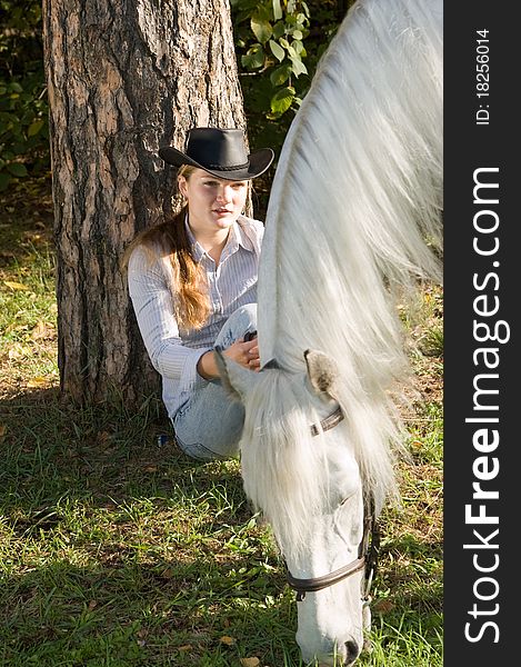 Portrait of young woman with her white horse on a green grass. Portrait of young woman with her white horse on a green grass