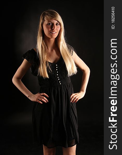 Beautiful young blond woman posing in a black dress