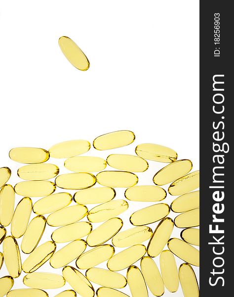 Gold pills or capsules backlit on white for medical or science use led by one. Gold pills or capsules backlit on white for medical or science use led by one.