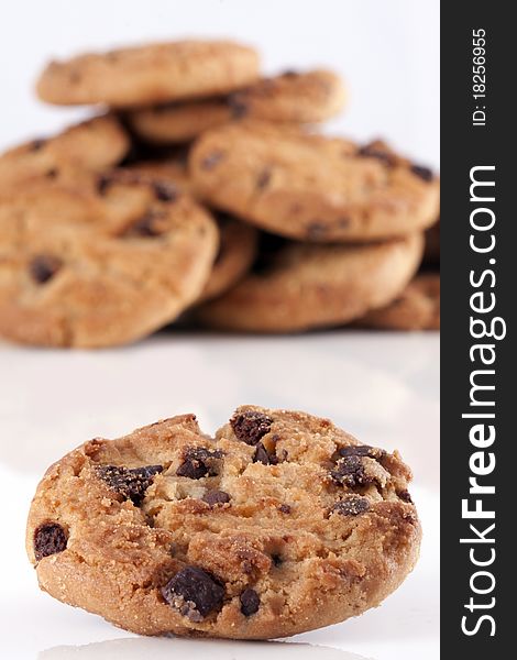 Pile of chocolate chip cookies, every cookie comes with a lot of chocolate chips, fresh baked just out of the oven isolated on white with copyspace